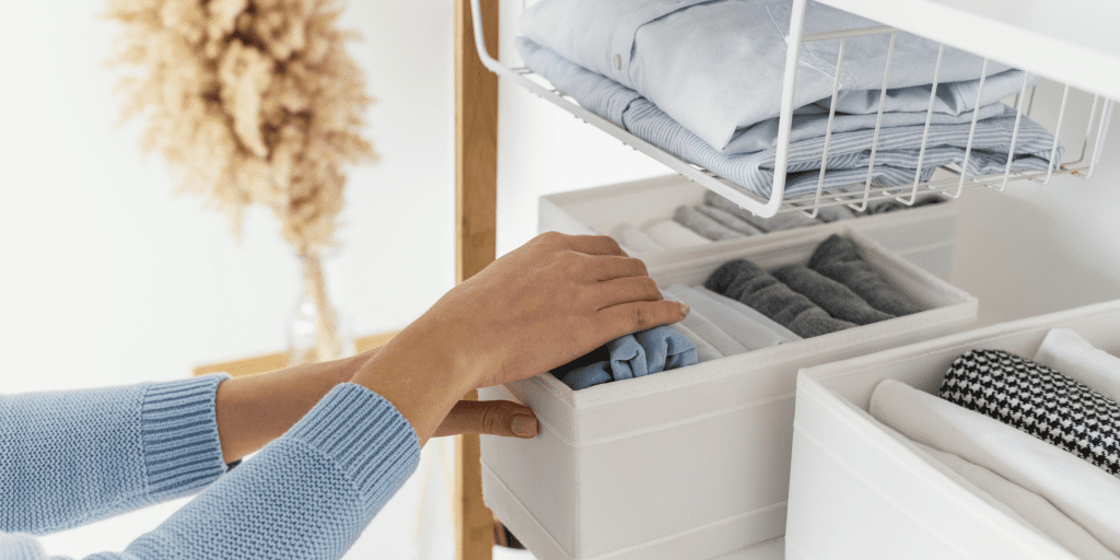woman in blue sweater organizing closet as quick self-care