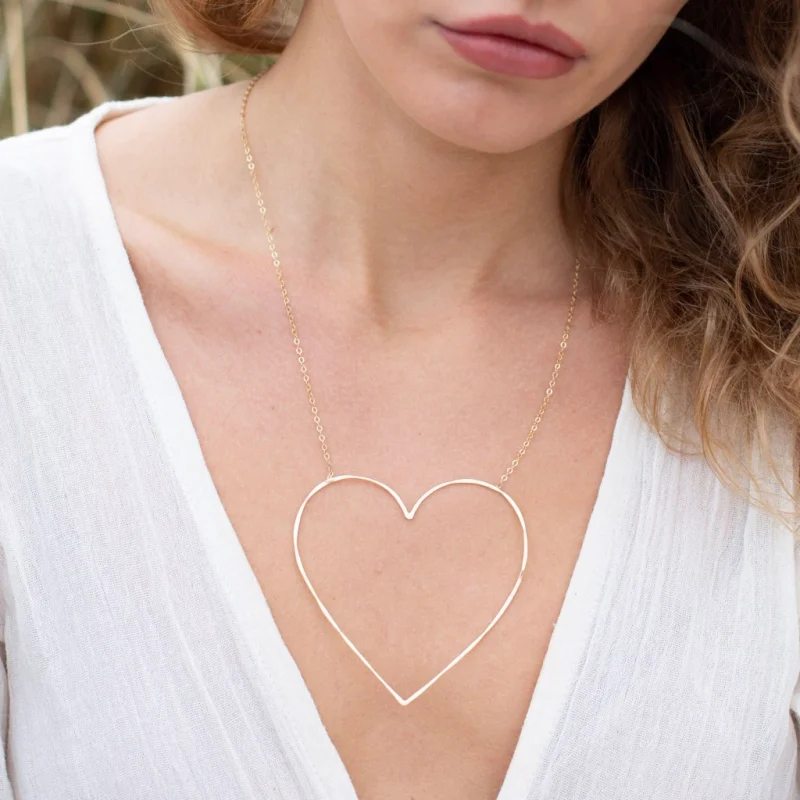 young woman wearing heart necklace low cut shirt